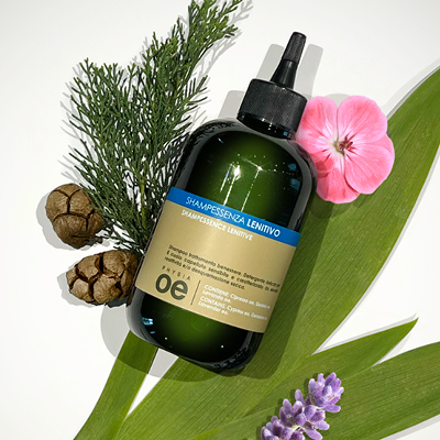 immagine del prodotto dello shampoo lenitivo ambientato su sfondo neutro e attorno tutti gli ingredienti